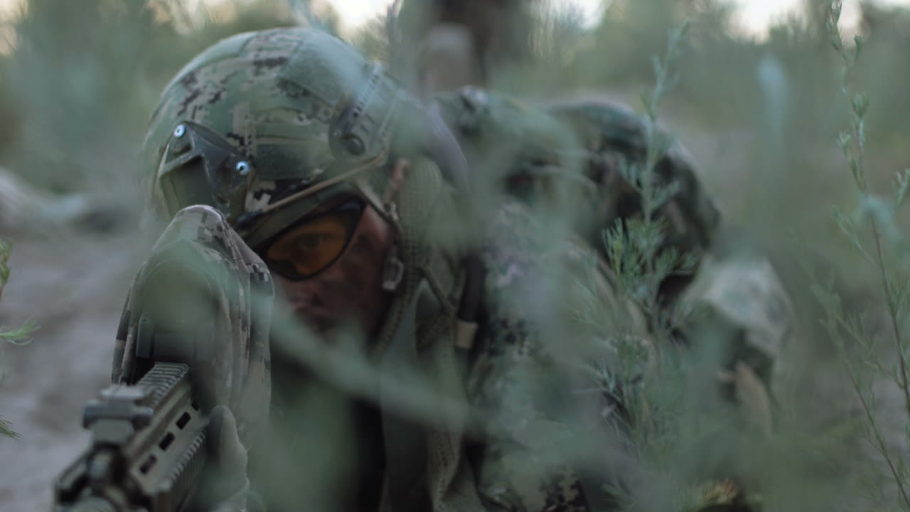 Soldier in camouflage uniform, hidden in the forest