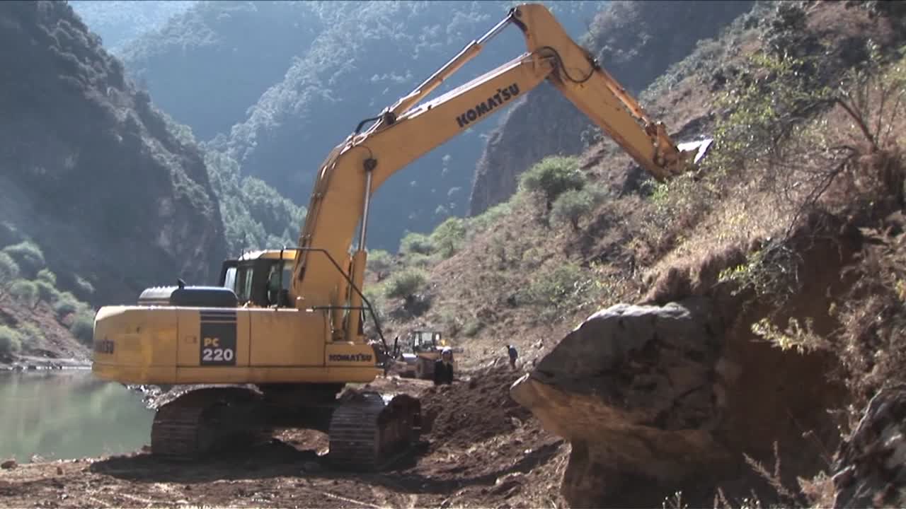 una pala de vapor mueve la tierra a lo largo de un camino rural