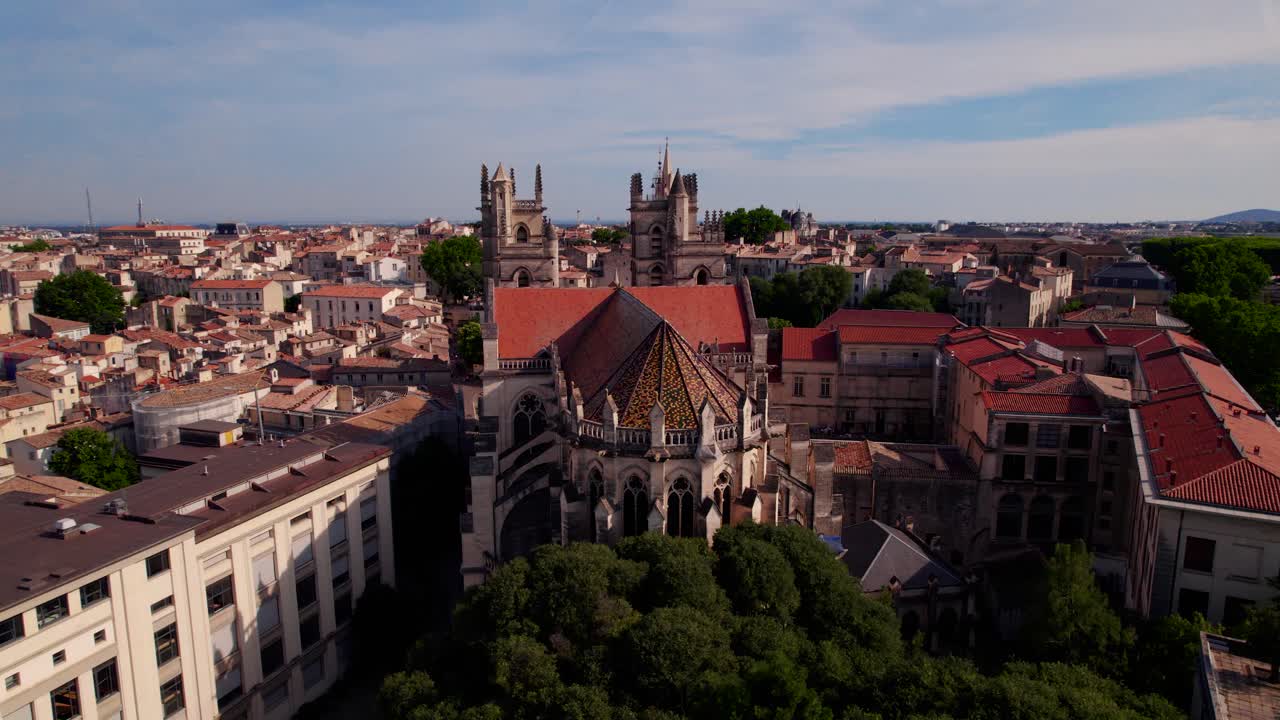 Kredsende luftfoto af en smuk antik kirke i Montpelliers centrum.