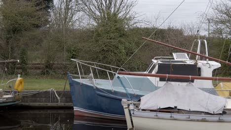 Kleine-Segelboote,-Die-Auf-Einem-Schmalen-Ländlichen-Kanaljachthafen-Schwimmen