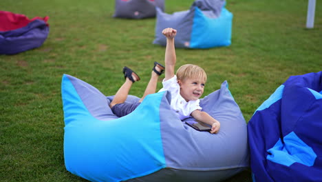 happy child playing with phone in bean bag