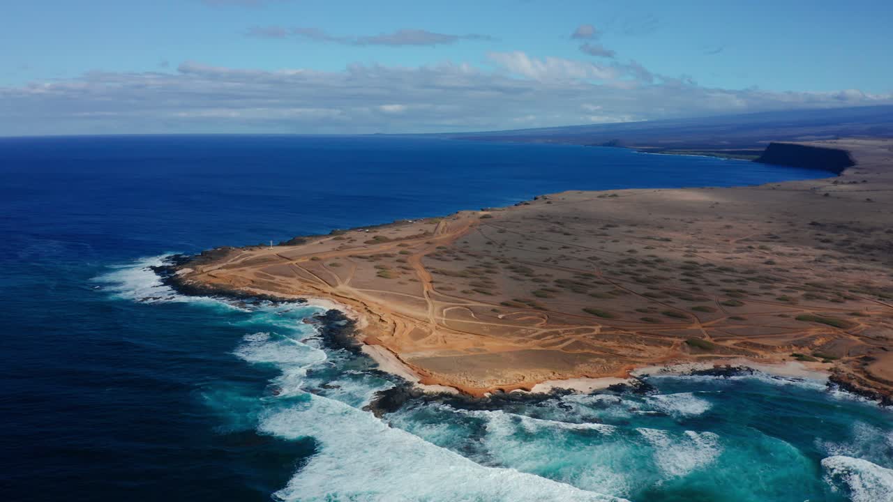 Expansive desert coastline at South Point on the Big Island of Hawaii. Rugged terrain meets the turquoise Pacific Ocean in this remote location.