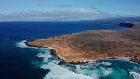 expansive desert coastline at south point on the big island of hawaii. rugged terrain meets the turquoise pacific ocean in this remote location.