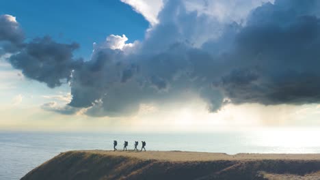 the four tourists with backpacks walking on the seascape background