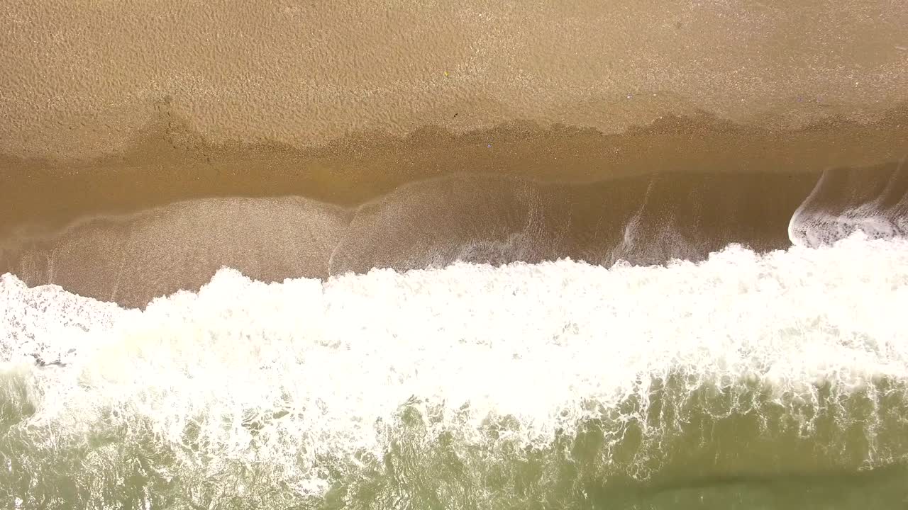 핑크색 모래 해변과 바다의 공중 전망: 바다 표면 텍스처를 루프, 상단 뷰 바다 파도가 느린 모션, 열대 모래 해수욕장과 파도 위를 날아, 해가 지는 해수욕장이 이 루프.