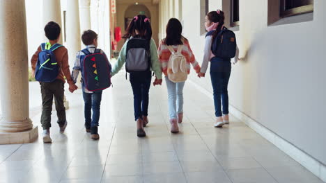 niños, escuela y tomándose de la mano con la espalda