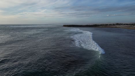 Drone-Flying-Over-Beautiful-Wave-Fading-Into-Cactus-Beach,-Famous-Surfing-Point,-South-Australia