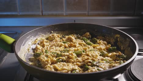 cocinar comida baja en carbohidratos para la cena, espárragos con huevos, en una sartén