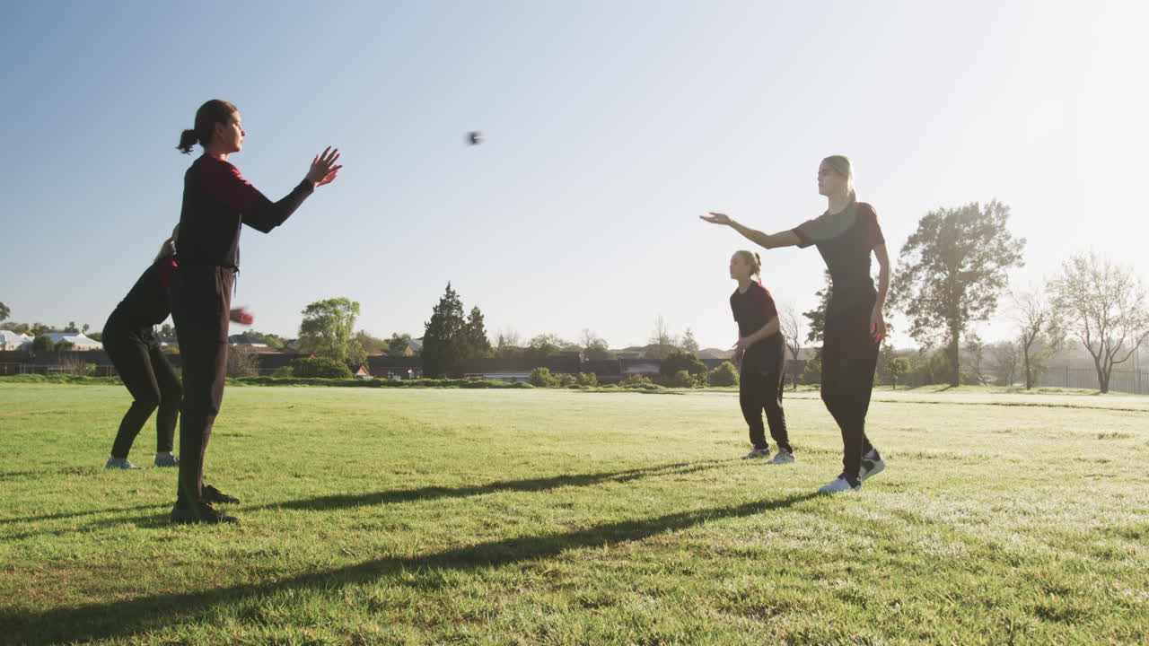Playing cricket on field, women practicing catching and throwing ball outdoors