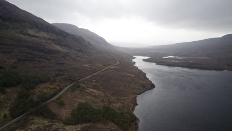 Toma-Aérea-De-Loch-Lurgainn-Y-La-Carretera-A-Lo-Largo-Del-Lago-Durante-El-Día-Nublado