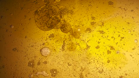 mixing water and oil, beautiful colors. yellow light. abstract macro background. water and oil bubbles. abstract light illumination