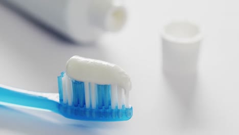 Video-of-close-up-of-toothbrush-and-paste-on-white-background
