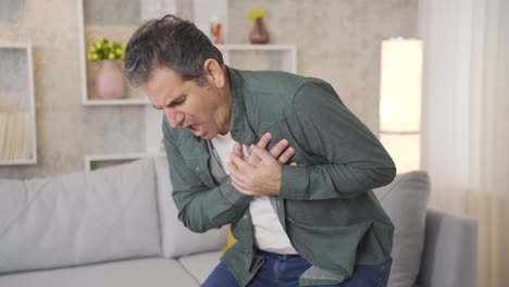 mature man suffering from unbearable pain at home having hand chest heart attack.