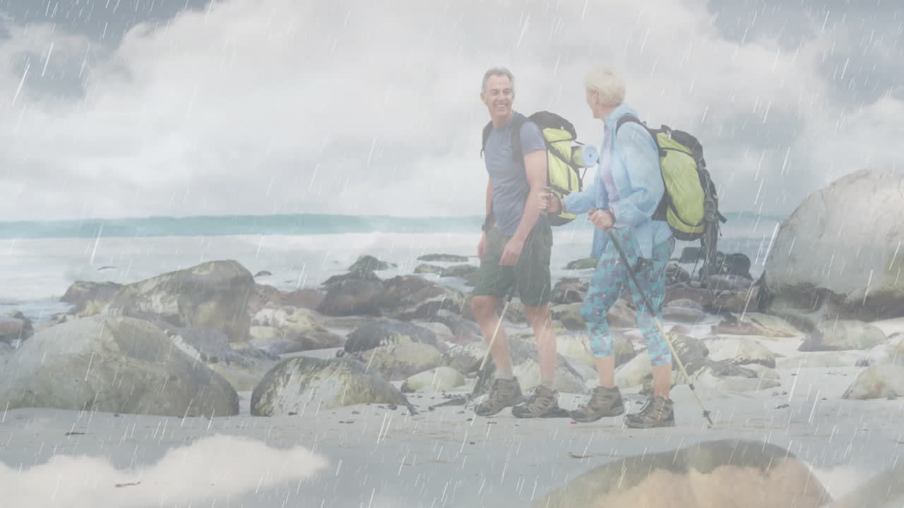 senior couple hiking along rocky coastline, viewing animated health data graph and map overlay