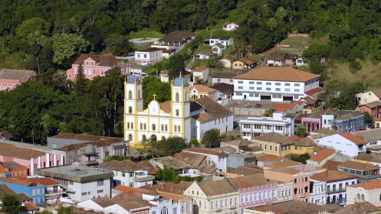 Slow, steady drone moves forward towards ornate facade of a historic church on a clear sunny day