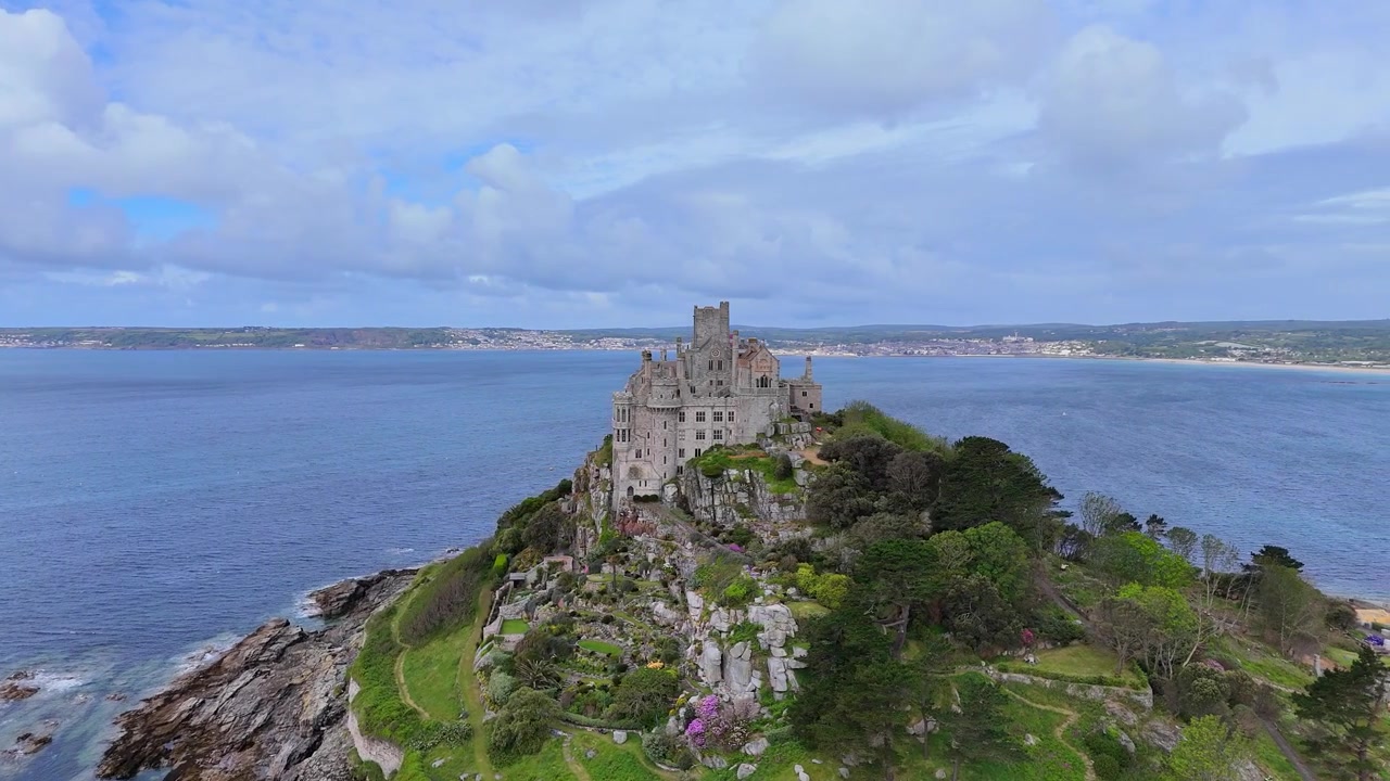 Panoramica aerea mozzafiato di St Michael's Mount e dei suoi giardini, Cornovaglia, ripresa in 4K con viste panoramiche sull'oceano e paesaggi costieri suggestivi.