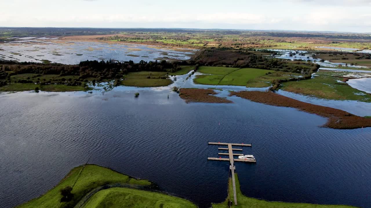 A 4K dropping drone reveal of the rath at Clonmacnoise on the River Shannon in flood Co Offaly Ireland
