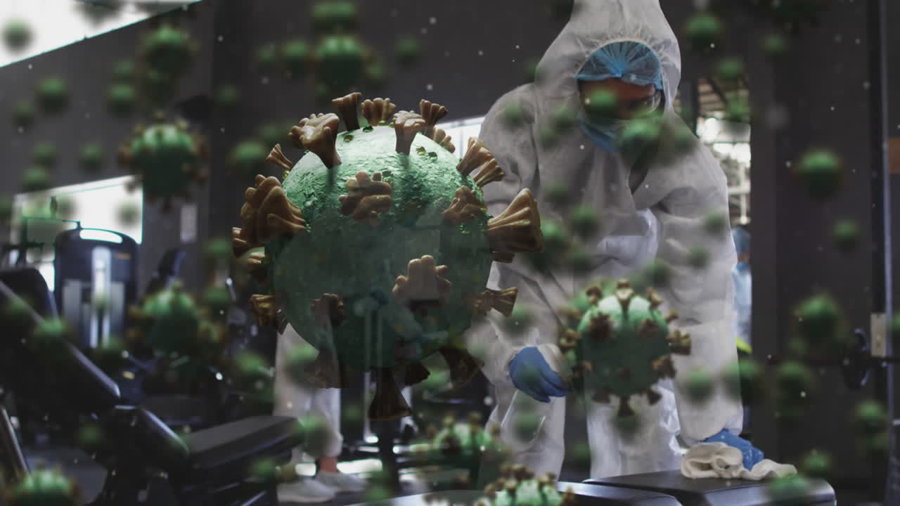 múltiples células de covid-19 flotando sobre un grupo de trabajadores de la salud que limpian el gimnasio usando desinfectante