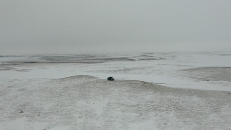 orbiting aerial shot of utv side by side on hill in barren tundra, 4k