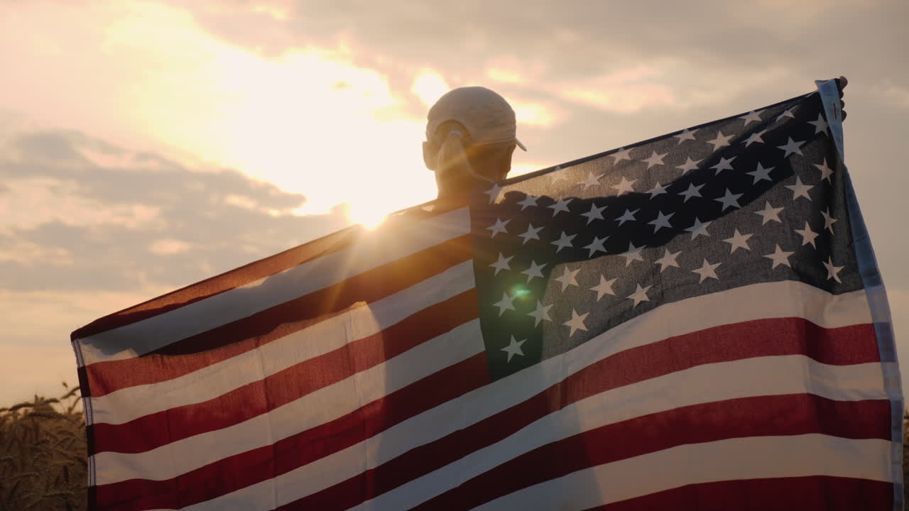 mujer de mediana edad con bandera de estados unidos se encuentra en un campo de trigo al atardecer concepto del día de la independencia
