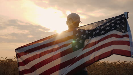 middle-aged woman with usa flag stands in a wheat field at sunset independence day concept