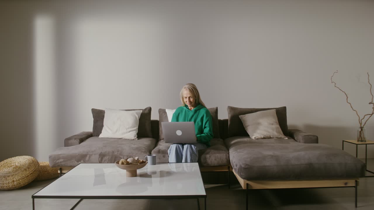 Woman using laptop on a sofa at home