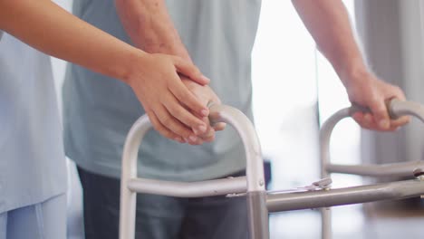 animation of hands of biracial female doctor taking care of caucasian senior man