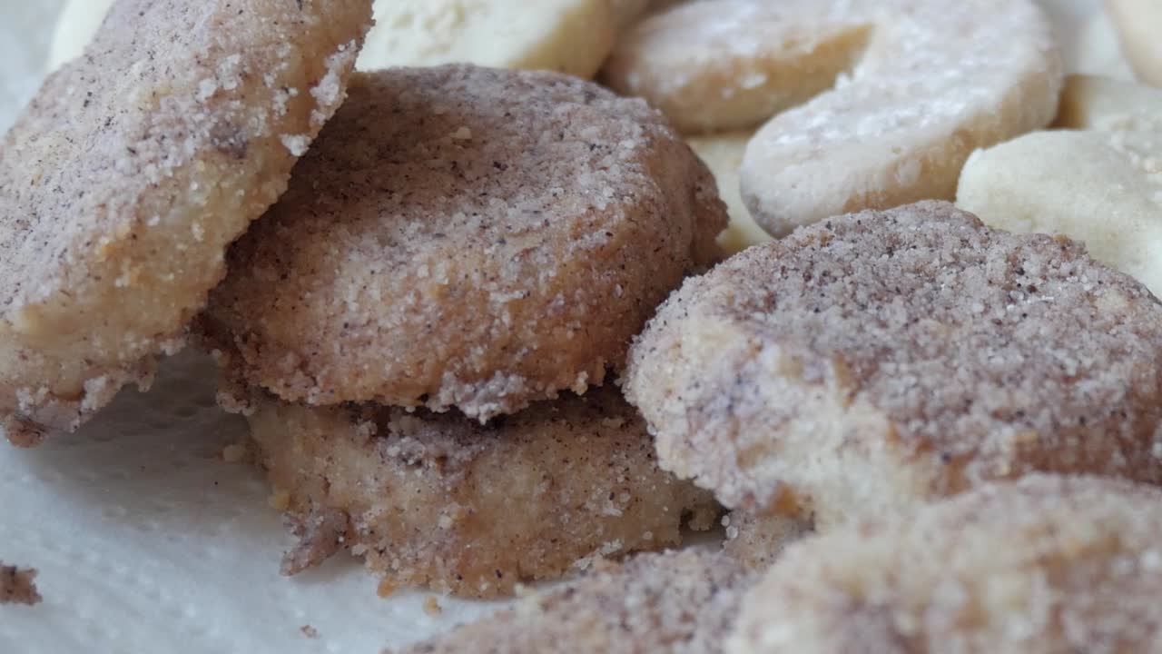 Zoom-in shot of homemade German Butterplätzchen, dusted with powdered sugar and placed on a plate, capturing the rich, delicious texture of this traditional sweet treat