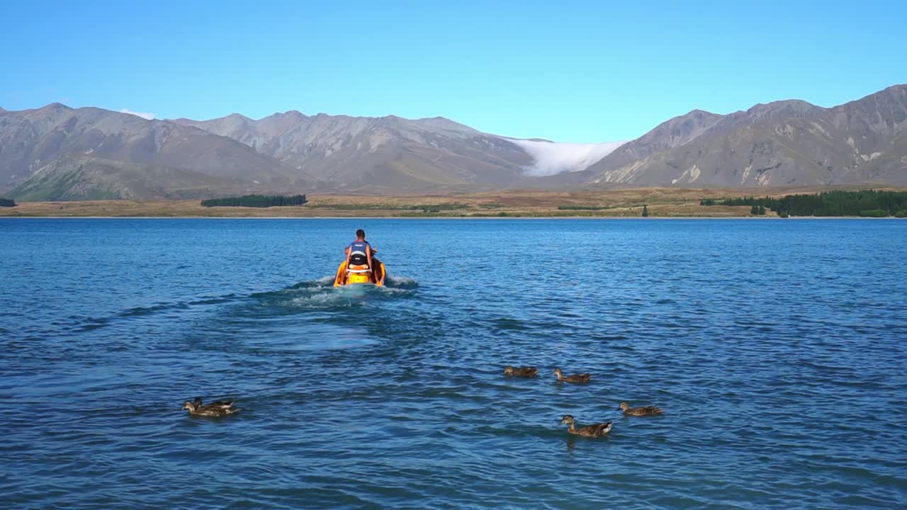 Two man on jet ski on Lake Tekapo, New Zealand with mountains in background