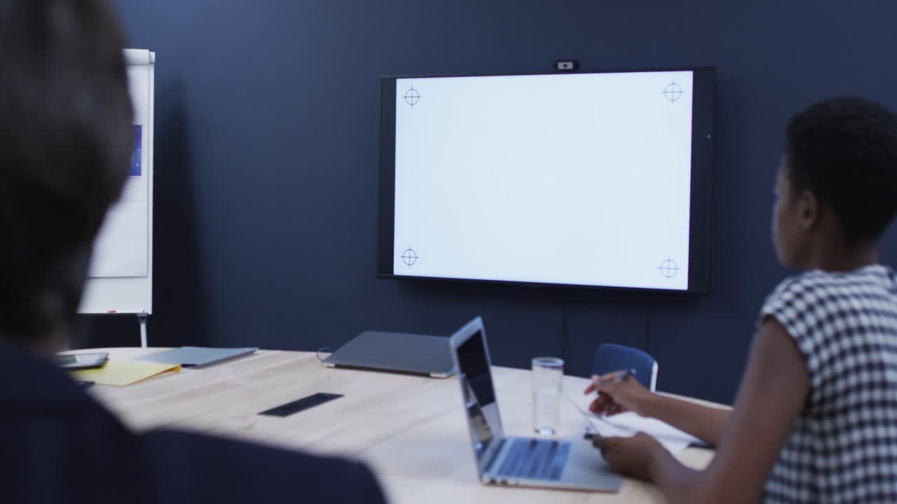 diversos colegas de negocios sentados mirando la pantalla en la reunión de la oficina
