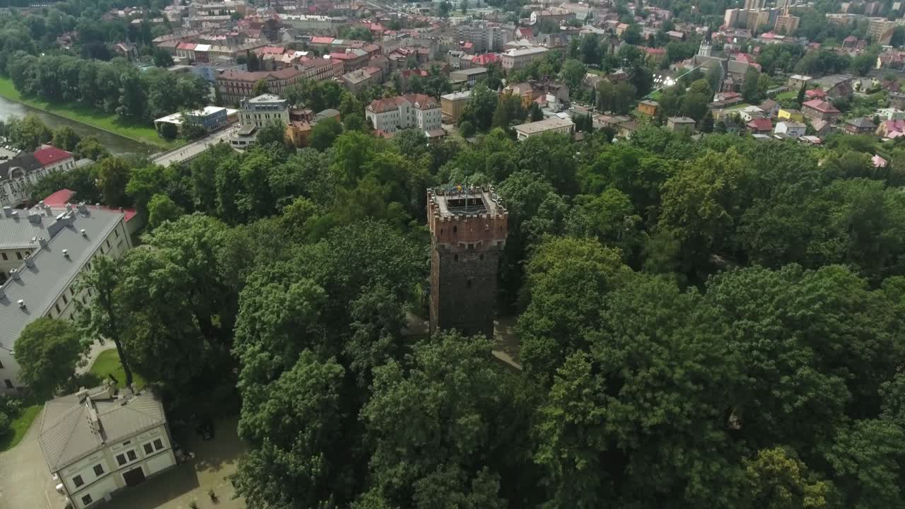 Et historisk middelaldertårn i en park i en by i Centraleuropa, optaget med en drone i 4K-opløsning.