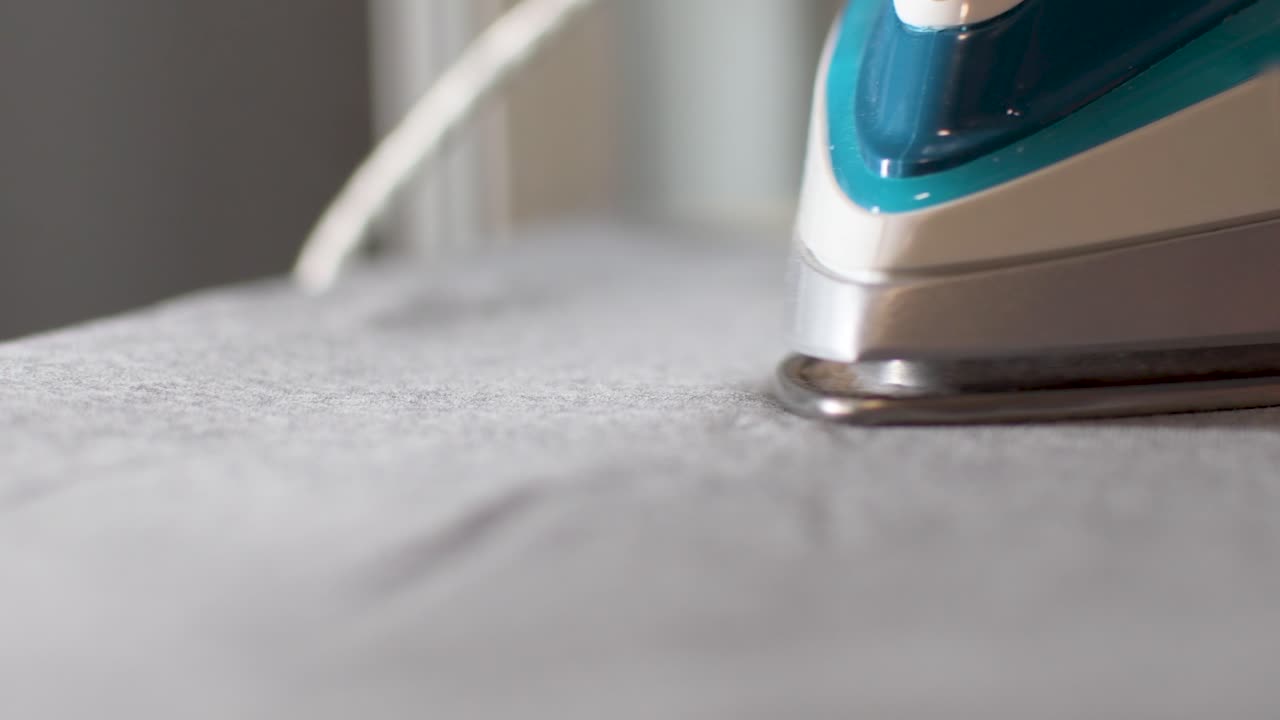 View of a steam iron sliding across the fabric