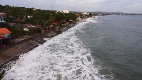 sea level rising causing coastal erosion in coastal areas with strong waves hitting and reaching the higher portion of the seawall during the typhoon in vietnam