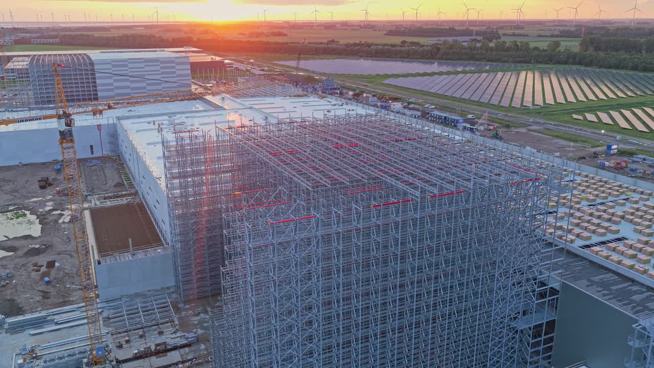 Sunlit construction pad, tower crane outlines future logistics center