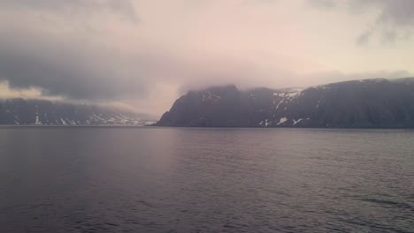 the view of clouds and mist from the deck of a cruise ship sailing along the coast of norway