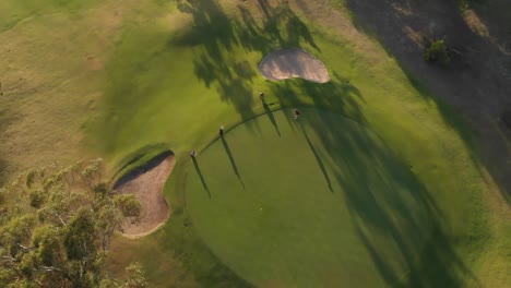 Two-diverse-male-golf-players-playing-golf-at-golf-course-on-sunny-day