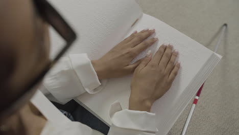 vista superior de las manos de la mujer tocando un libro