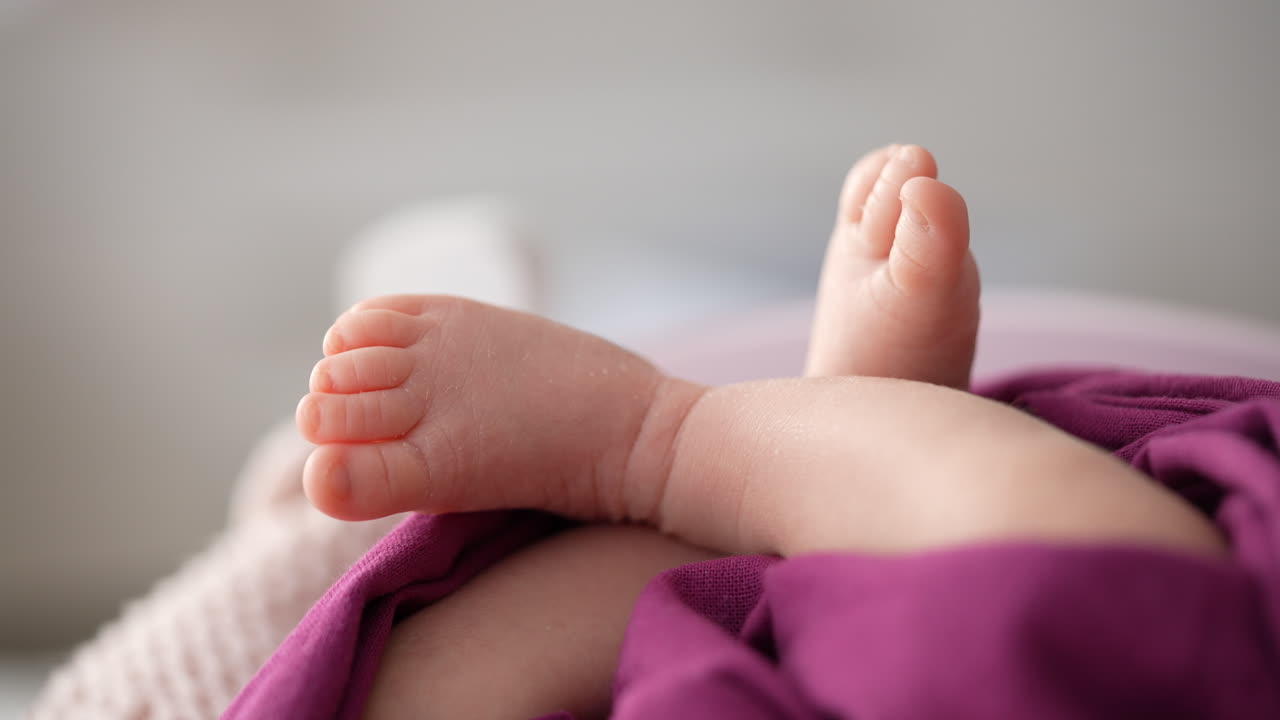 Close-up of baby feet on purple cloth