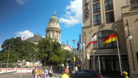 berlin’s gendarmenmarkt with cathedral and nearby modern hotel displaying german and austrian flags