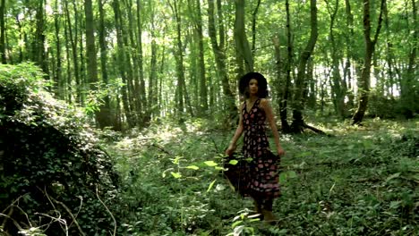 young, trendy woman in long dress twirls in the middle of a forest