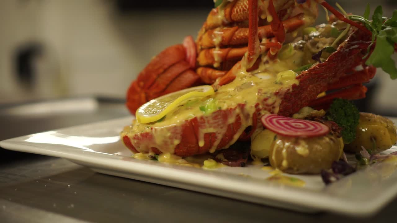 presentación de comida de cangrejo de río de nueva zelanda, con ensalada, papas, limón y salmón en un restaurante de lujo - detalle de cierre