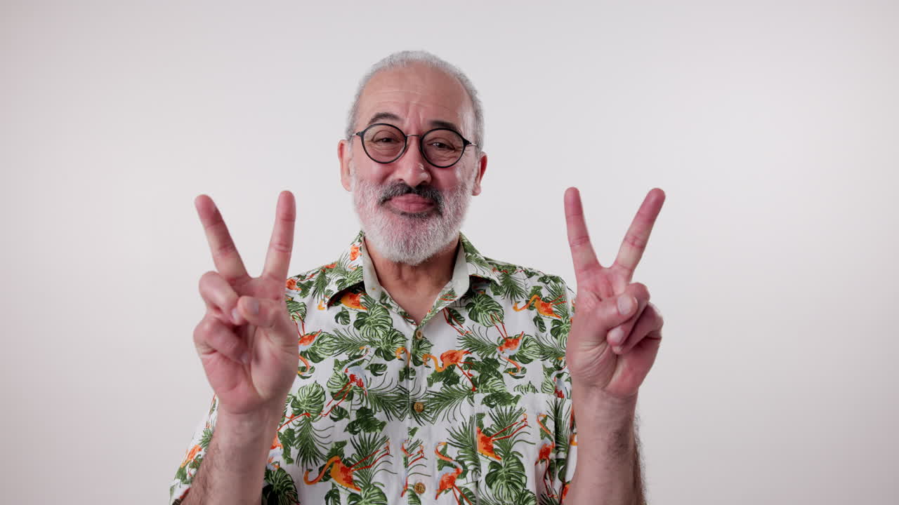 Senior man in Hawaiian shirt making peace sign