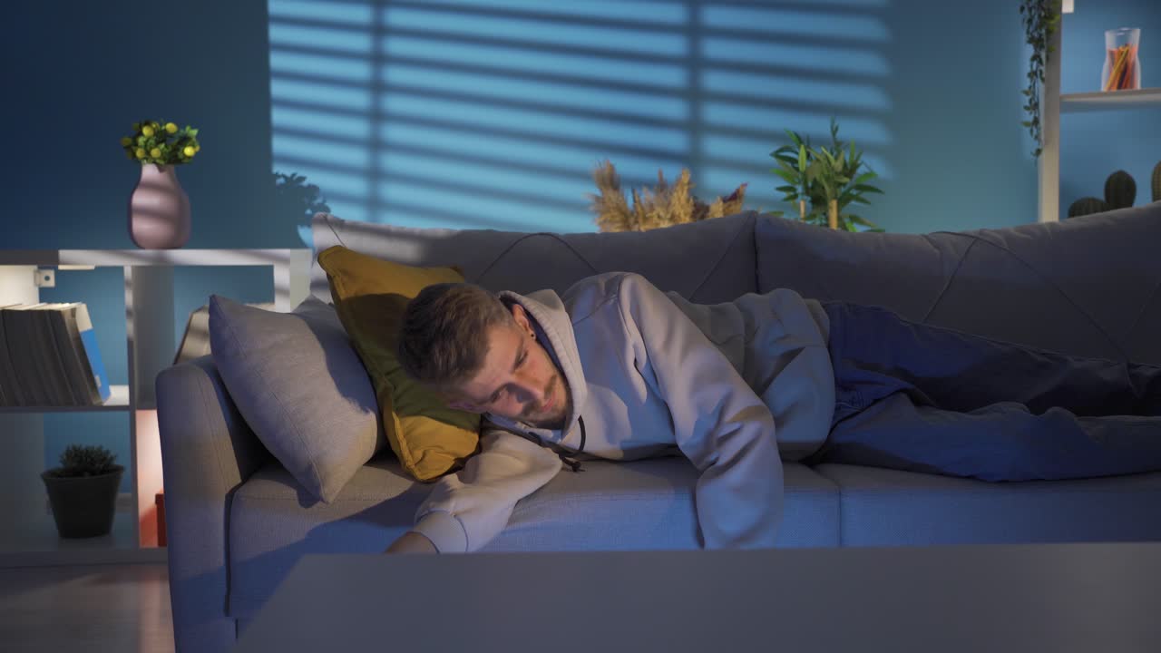 joven frustrado sentado en el sofá, sintiéndose mal moralmente después de una discusión, abandonado.