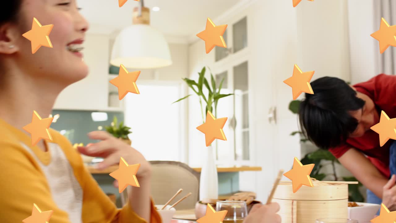 Son approaching and hugging mother at table, sparking orange confetti with chopsticks for marketing