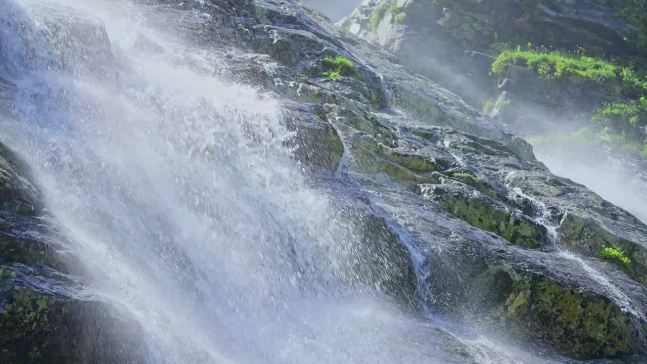 Powerful Waterfall Cascading Down Rocky Mountain with Splashing Water and Mist