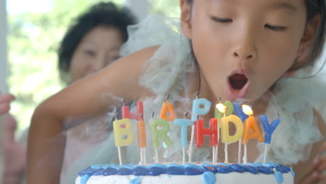 tiro em câmera lenta como menina sopra velas no bolo de aniversário