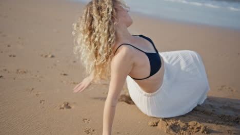 girl performing dance sand sunny beach close up. sensual woman moving smoothly