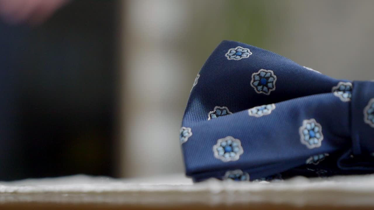 крупный план фрагмента голубой галстука жениха, с молодоженцами, оживленными на заднем плане