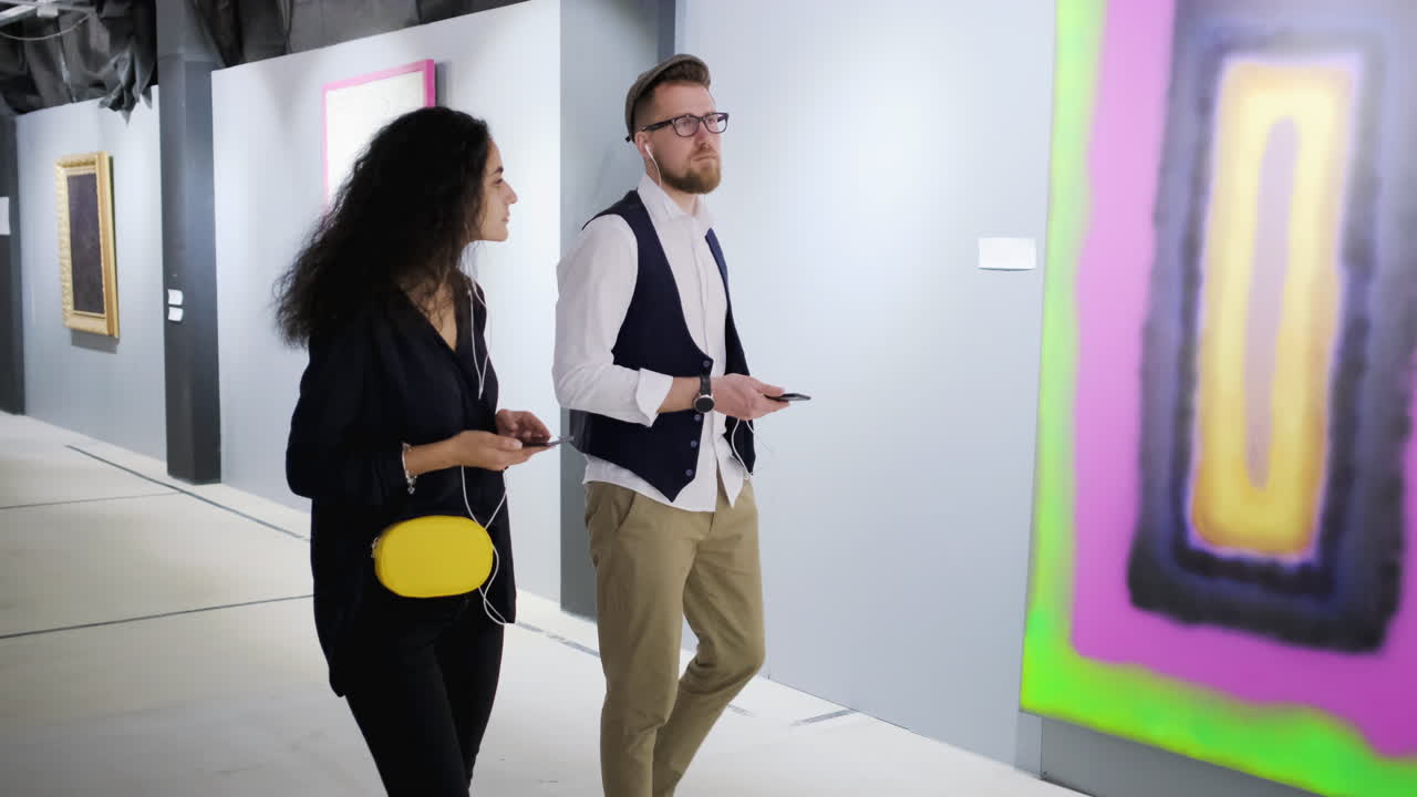 una pareja viendo arte moderno en una galería.