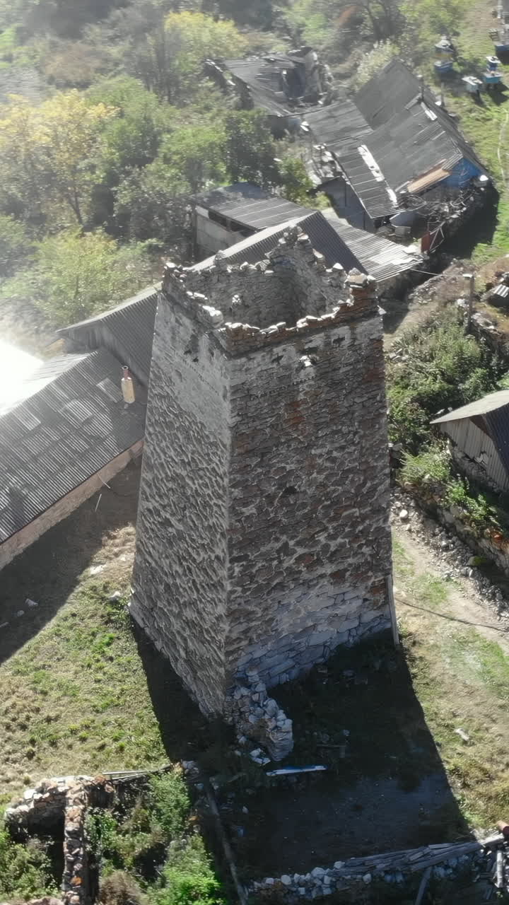 Widok z lotu ptaka na starożytną kamienną wieżę w wiejskiej górskiej wiosce